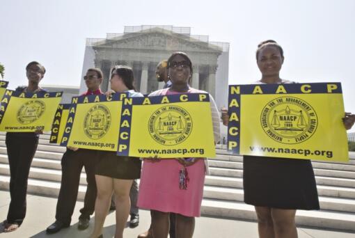 FILE - Representatives from the NAACP Legal Defense Fund stand outside the Supreme Court in Washington, June 25, 2013, awaiting a decision in Shelby County v. Holder, a voting rights case in Alabama. A U.S. Supreme Court decision a decade ago that tossed out the heart of the Voting Rights Act continues to reverberate across the country. Republican-led states continue to pass voting restrictions that, in several cases, would have been subject to federal review had the court left the provision intact. (AP Photo/J.