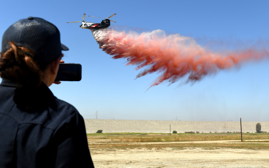 A helicopter drops fire retardant over a field during a recent demonstration in Irwindale. The helicopter can hold 3,000 gallons of water or fire retardant and operate at night.