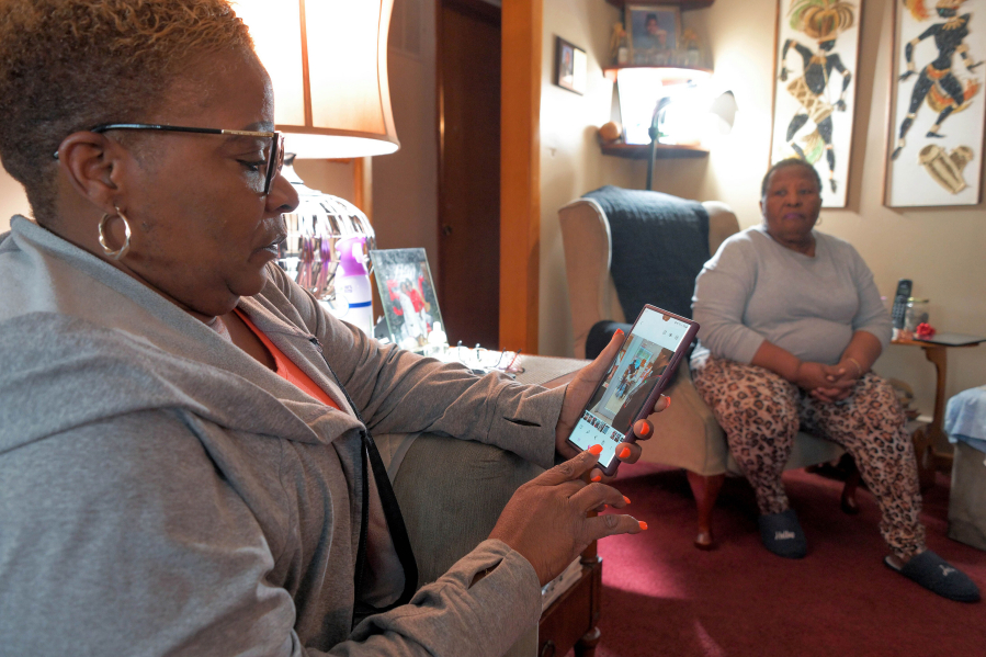 Samantha Hart, daughter of Henry Hart, who has dementia, looks at a photo of the release of her father from police custody while her mother, Rosalind Hart, looks on at the Hart home. The family filed a complaint with Baltimore County after his health declined when he was taken to jail.