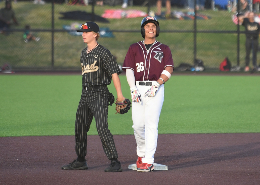 Raptors player Jacob Sharp, right, smiles after hitting a RBI double Tuesday, June 27, 2023, during the Raptors??? game against Bend at the Ridgefield Outdoor Recreation Complex.