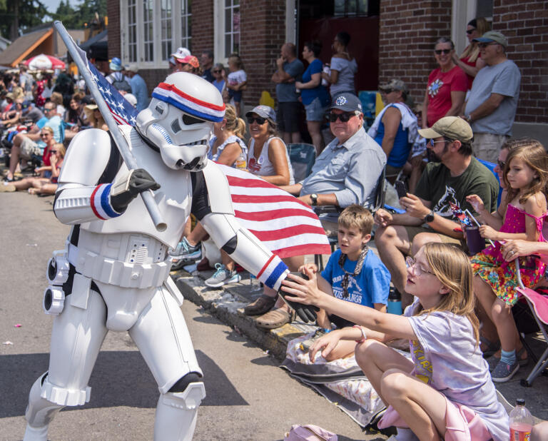 A Storm Trooper high fives parade goers Tuesday, July 4, 2023, during an Independence Day parade in Ridgefield.