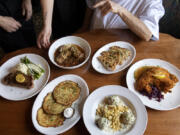 Gustav's new menu includes dishes pictured here like a New York strip steak, clockwise from left, stuffed cabbage rolls, garlic cheese bread, chicken schnitzel, German meatballs in a caper sauce with spaetzle and potato pancakes.