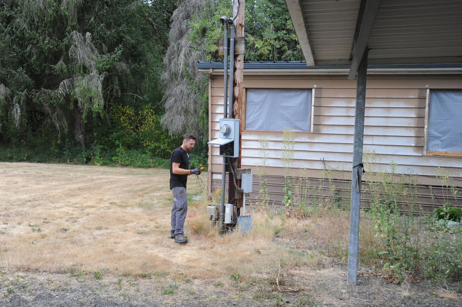 Electrician Tim Benack from Clark County Public Works begins removing the electric infrastructure at the caretaker residence at Daybreak Regional Park on Monday. The caretaker residences at Daybreak and Lucia Falls regional parks are being removed to make room for new recreational vehicle pads.