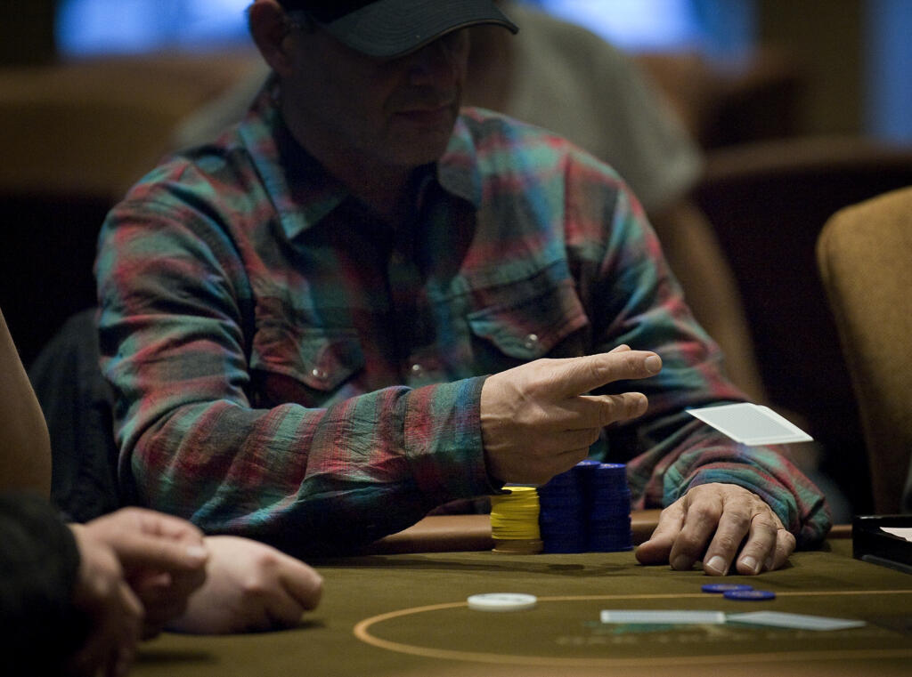 A poker player folds during a Texas Hold 'Em tournament at a cardroom in La Center.