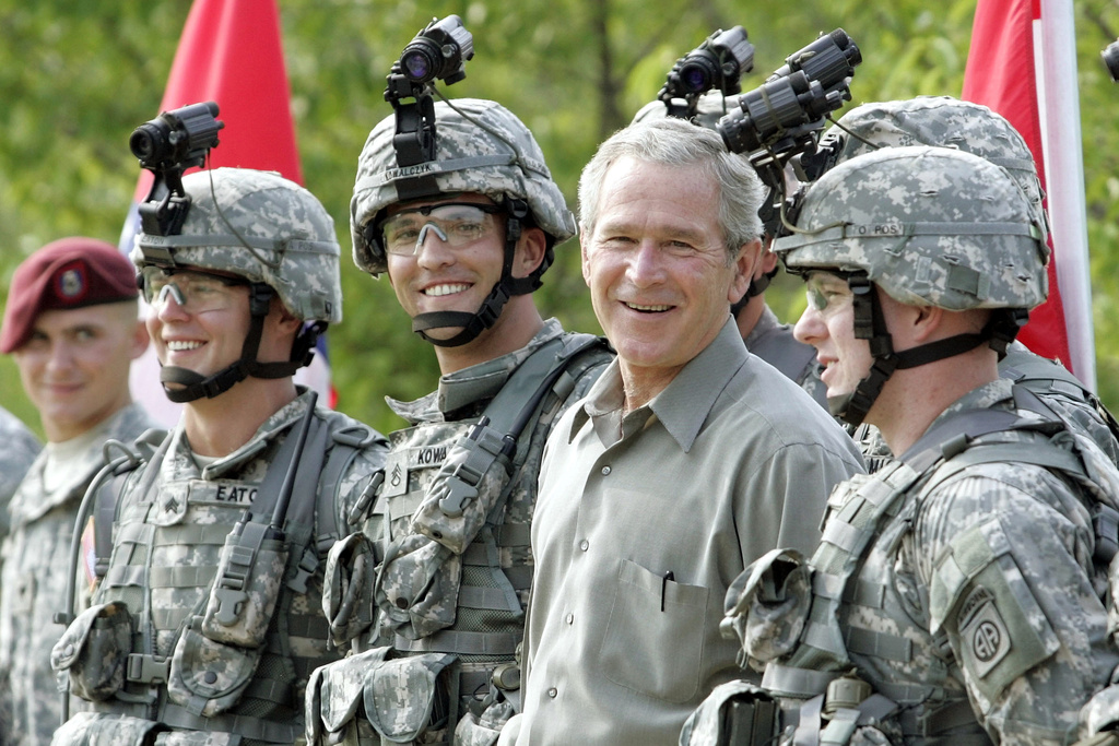 FILE - President George W. Bush smiles as he poses for a group photo with military personnel during his visit to U.S. Army Special Operations Command at Fort Bragg, N.C., July 4, 2006.