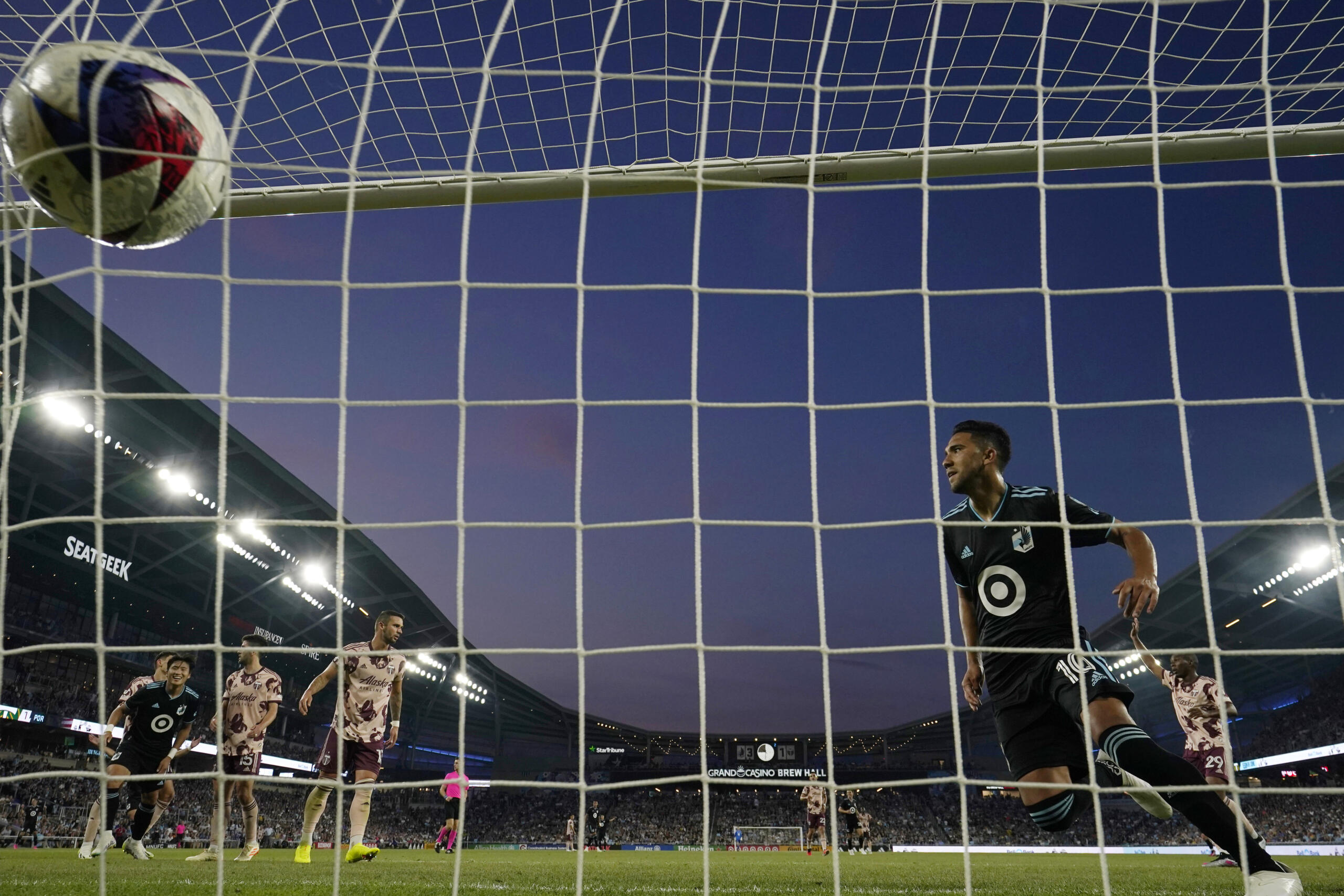 Minnesota United midfielder Emanuel Reynoso, right, scores against the Portland Timbers during the second half of an MLS soccer match Saturday, July 1, 2023, in St. Paul, Minn.