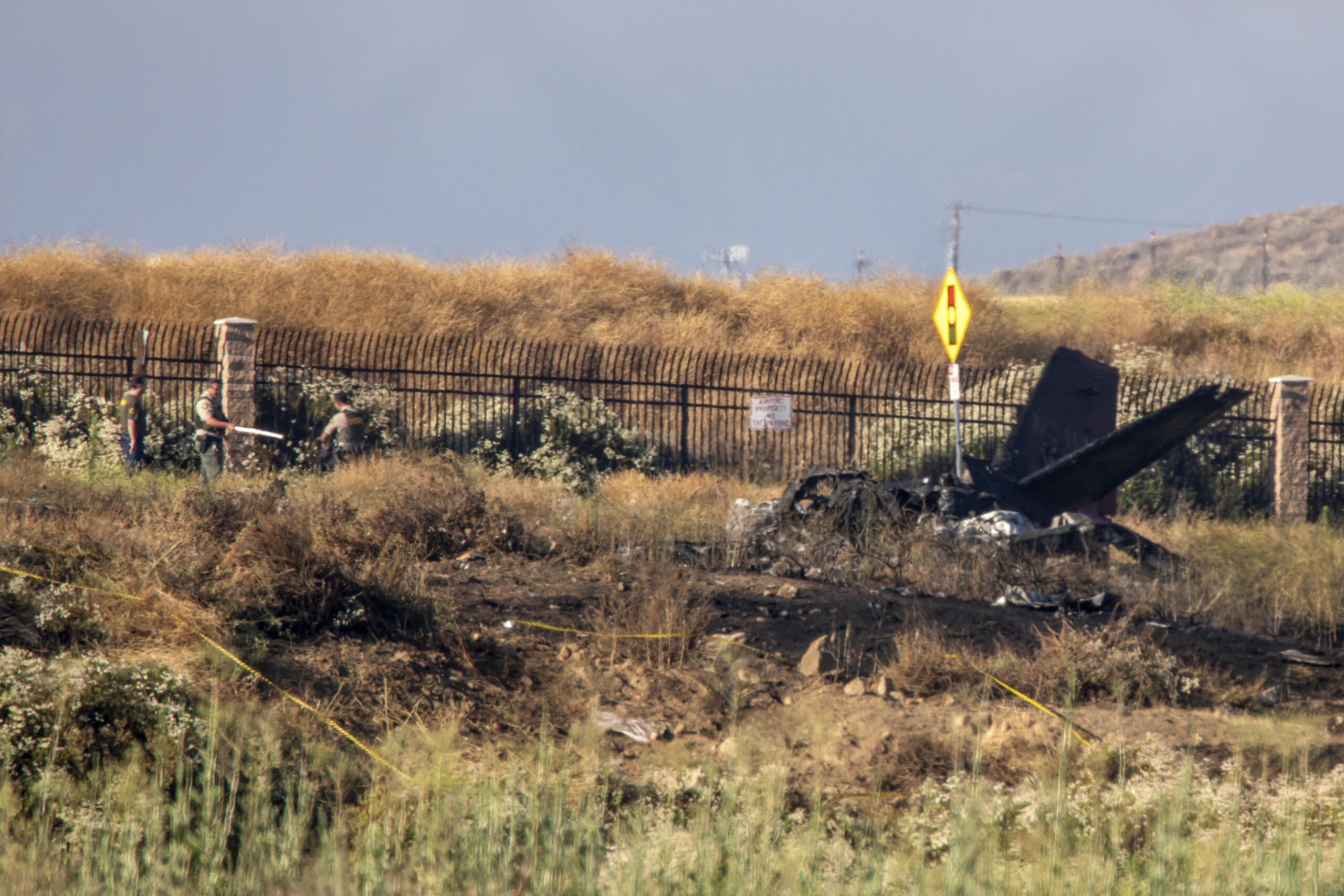 Charred remains of a Cessna lie near the landing approach at French Valley Airport, in Murrieta, Calif., Saturday, July 8, 2023. The Los Angeles Times reports that, according to CalFire, six people died in the crash.