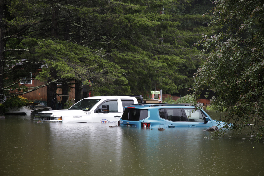 Floodwaters rise in Bridgewater, Vt., Monday, July 10, 2023, submerging parked vehicles and threatening homes near the Ottauquechee River. Heavy rain drenched part of the Northeast, washing out roads, forcing evacuations and halting some airline travel.