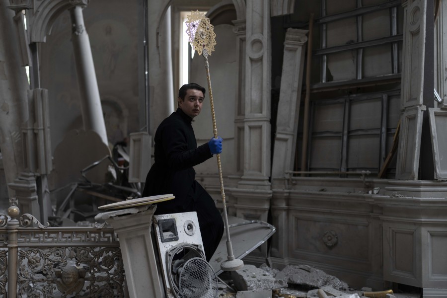 A church personnel salvages items while helping clean up inside the Odesa Transfiguration Cathedral after it was heavily damaged in Russian missile attacks in Odesa, Ukraine, Sunday, July 23, 2023. (AP Photo/Jae C.