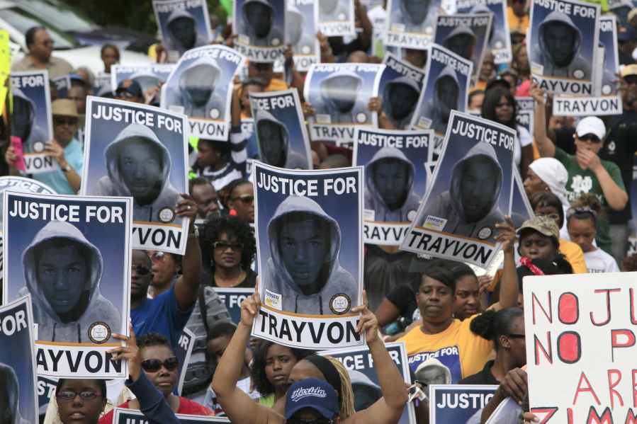 FILE - Protesters hold signs during a march and rally for slain teenager Trayvon Martin, March 31, 2012, in Sanford, Fla. The Black Lives Matter movement hits a milestone on Thursday, July 13, 2023, marking 10 years since its 2013 founding in response to the acquittal of the man who fatally shot Martin. Gunned down in a Florida gated community where his father lived in 2012, Martin was one of the earliest symbols of a movement that now wields influence in politics, law enforcement and broader conversations about racial progress.
