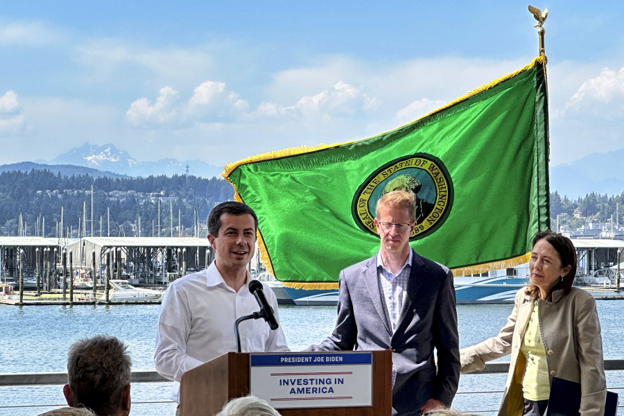 U.S. Transportation Secretary Pete Buttigieg, left, alongside U.S. Rep. Derek Kilmer and U.S. Sen. Maria Cantwell, speaks about a $9.4 million federal grant dedicated to the replacement of the Port Orchard Marina breakwater in Port Orchard, Wash.