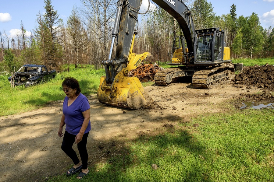 Carrol Johnston, who lost her home in a May wildfire, walks through her property in the East Prairie Metis Settlement, Alberta, on Wednesday, July 4, 2023. Johnston, who has been living in a nearby town, is awaiting a modular home so she can return to the land.