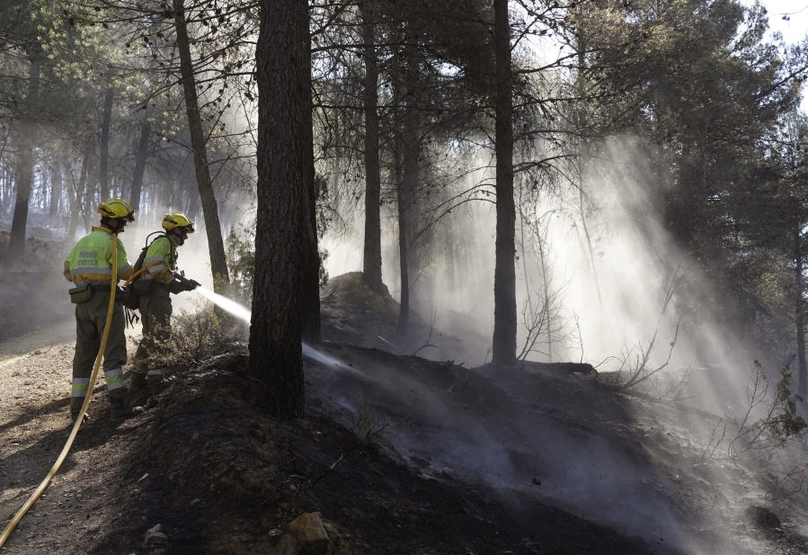 FILE - Firefighters try to extinguish a forest fire in Fuente la Reina, Castellon de la Plana, Spain, March 29, 2023. Spain suffered the biggest losses from wildfires of any European Union country last year amid a record-hot 2022, and there is worry that this year's fire season could also be bad.