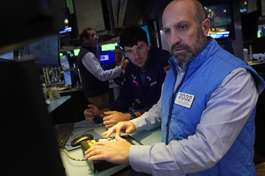 Specialist James Denaro, right, works at his post on the floor of the New York Stock Exchange, Thursday, July 13, 2023. Wall Street is adding to its winning week Thursday following the latest signal that inflation is continuing to ease its chokehold on the economy.