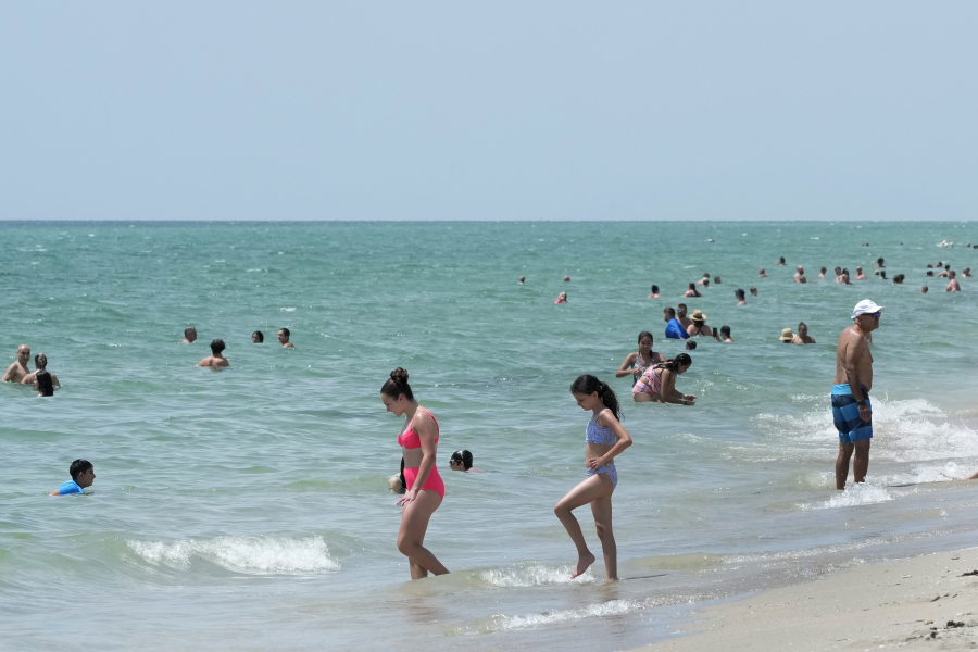 Beachgoers take a dip in the Atlantic Ocean at Hollywood Beach, on Monday in Hollywood, Fla.