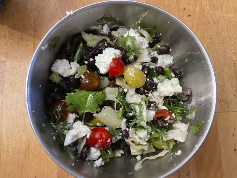 A salad made with half-can of black beans, feta cheese, celery, scallions, cilantro, cherry tomatoes and cabbage. (Beth J.