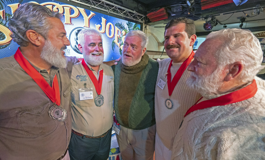 In this Saturday, July 22, 2023, photo provided by the Florida Keys News Bureau, finalists in the 2023 Hemingway Look-Alike Contest including, from left, Paul Phillips, Tim Stockwell, Gerrit Marshall, Chris Dutton and Bat Masterson, converse with each other while awaiting the judges' results at Sloppy Joe's Bar in Key West, Fla. The competition was a highlight of the annual Hemingway Days festival that ends Sunday, July 23. Ernest Hemingway lived in Key West throughout most of the 1930s. After 11 years of competing, Marshall, a Madison, Wisc., resident, achieved success on his 68th birthday.
