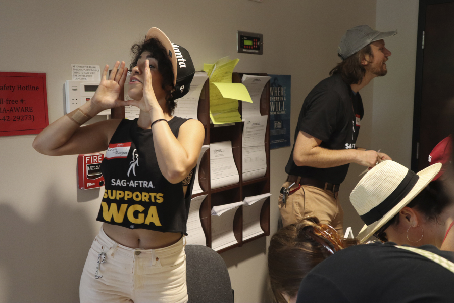 Actor Diany Rodriguez helps attendees sign in at a SAG-AFTRA rally in Atlanta on July 17, 2023. Rodriguez is a strike captain for the union's Atlanta chapter and sees the ongoing strike as a "part of a larger labor movement that we're seeing in the States." (AP Photo/R.J.