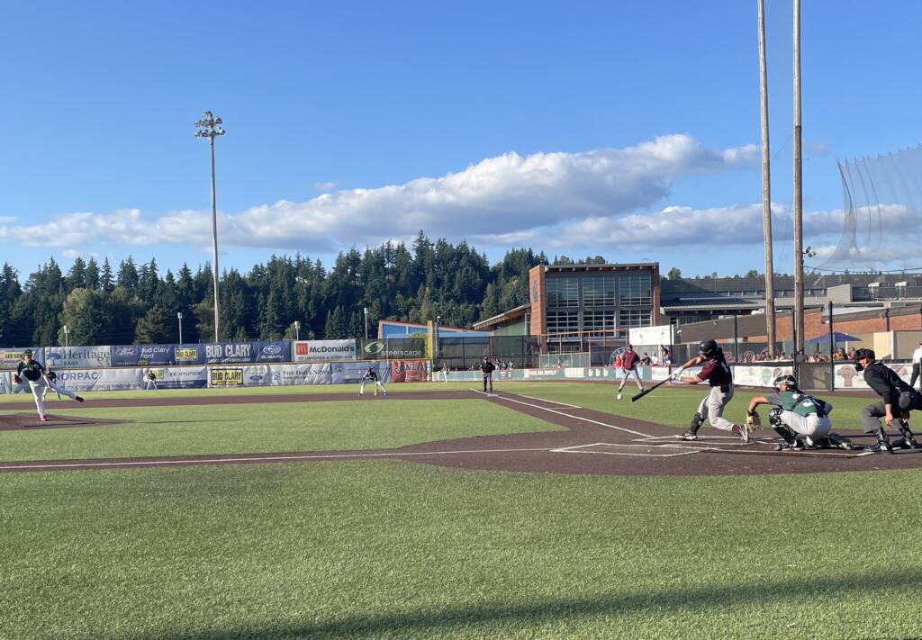 Ridgefield's Jake Tsukada connects on a pitch against Cowlitz's Jayden Vinson during a game between the Raptors and Black Bears on Thursday, July 27, 2023, at David Story Field in Longview.