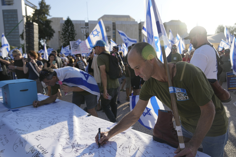 Israeli military reservists sign a declaration of refusal to report for duty to protest against plans by Prime Minister Benjamin Netanyahu's government to overhaul the judicial system, in Tel Aviv, Israel, Wednesday, July 19, 2023. Divisions over the contentious government plan have infiltrated the country's military, where reservists in key units have pledged not to show up for duty if the legislative changes are approved.