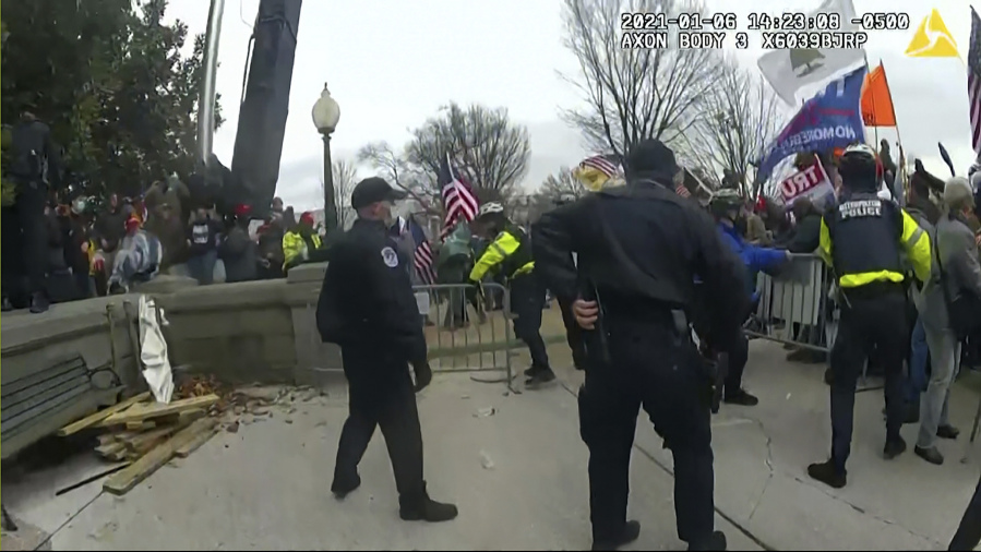 FILE - This image from video from a police worn body camera from the Jan. 6, 2021, riot at the U.S. Capitol. Law enforcement officials say, Taylor Taranto, a man wanted for crimes related to the Jan. 6, 2021, insurrection at the U.S. Capitol has been arrested in the Washington neighborhood where former President Barack Obama lives. Taranto was seen a few blocks from the former president's home, and he fled even though he was chased by U.S. Secret Service agents.
