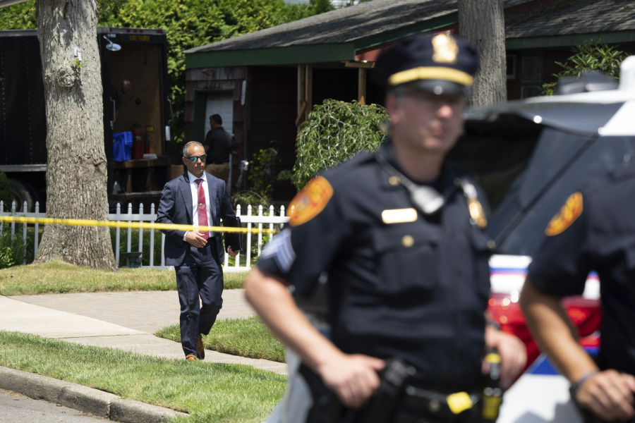 Police officers stand guard as law enforcement searches the home of Rex Heuermann, Saturday, July 15, 2023, in Massapequa Park, N.Y. Heuermann, a Long Island architect, was charged Friday, July 14, with murder in the deaths of three of the 11 victims in a long-unsolved string of killings known as the Gilgo Beach murders.