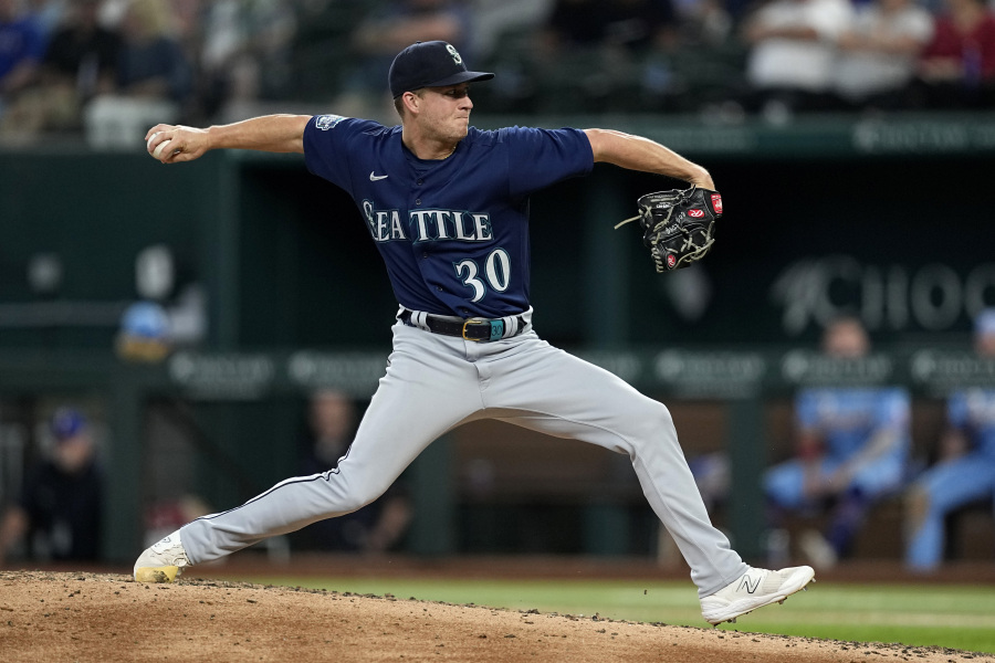 Seattle Mariners relief pitcher Trevor Gott winds up to throw to the Texas Rangers in the sixth inning of a baseball game, Sunday, June 4, 2023, in Arlington, Texas.