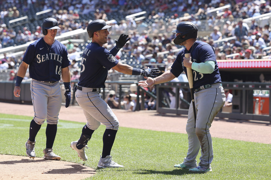 Seattle Mariners' Dylan Moore (25) celebrates with Ty France (23) after Moore hit a home run during the fifth inning of a baseball game against the Minnesota Twins, Wednesday, July 26, 2023, in Minneapolis.