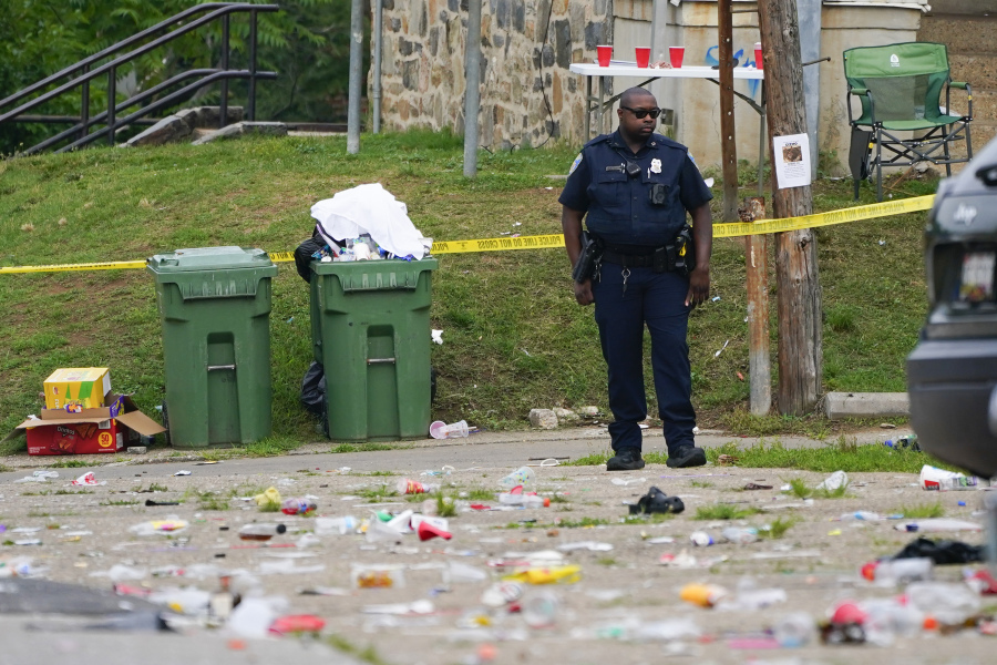 A police officer stands in the area of a mass shooting Sunday in Baltimore. Two people were killed and 28 wounded in the incident.