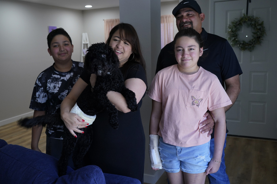 Mayah Zamora, front right, a survivor of the mass shooting at Robb Elementary in Uvalde, Texas, poses for a photo with her brother Zach, left, mom Christina, dad Ruben, back right, and her service dog Rocky at their home in San Antonio, Tuesday, June 27, 2023. Besides medical bills and the weight of trauma and grief, mass shooting survivors and their family members contend with scores of other changes that show how thoroughly their lives have been upended by violence.