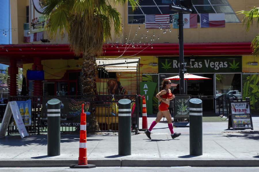 A person jogs on the Las Vegas strip during a heat advisory, Friday, July 14, 2023 in Las Vegas. Nearly a third of Americans were under extreme heat advisories, watches and warnings Friday, including in Las Vegas as a high pressure dome moves west from Texas.