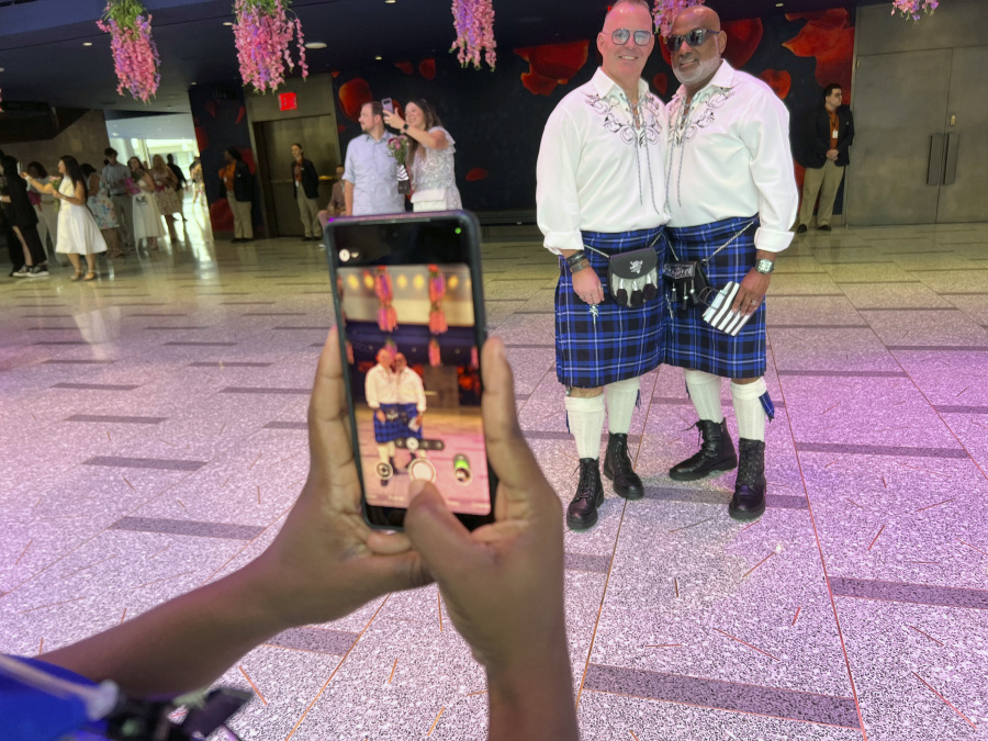 Archley Prudent, right, and his spouse of 12 years, Hugh, pose for a photo, Saturday, July 8, 2023, at New York's Lincoln Center. They were married as soon as gay marriage became legal in New York, but never had a proper wedding, so they joined 700 other couples for a mass wedding.