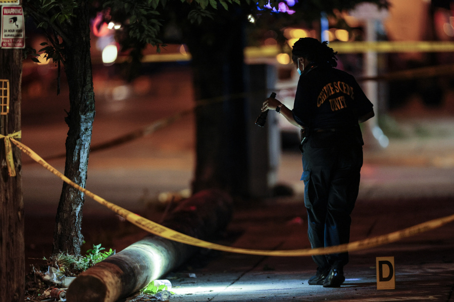 Police investigate the scene of a shooting Monday, July 3, 2023 in Philadelphia. Police say a gunman in a bulletproof vest has opened fire on the streets of Philadelphia, killing several people and wounding two boys before he surrendered to responding officers. (Steven M.
