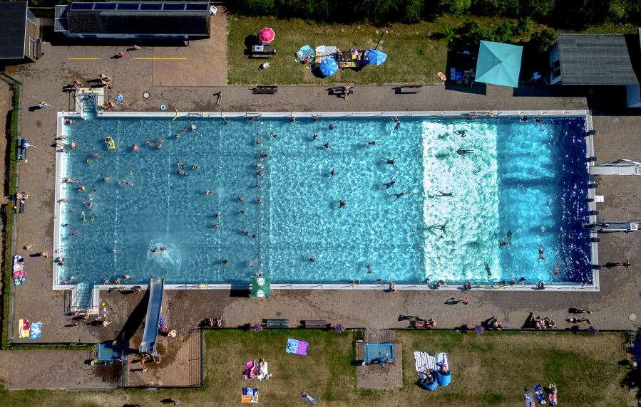People spend time in a public pool in Wehrheim near Frankfurt, Germany, on a hot Saturday, July 8, 2023.