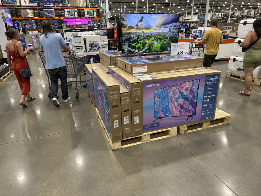 Shoppers glide past a display of big-screen televisions in a Costco warehouse on Tuesday, July 11, 2023, in Sheridan, Colo. On Tuesday, July 18, the Commerce Department releases U.S. retail sales data for June.