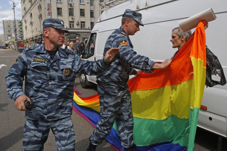 FILE - Russian police officers detain a gay rights activist with his flag during an attempt to hold a gay pride parade in Moscow, Russia, on May 27, 2012. Russian lawmakers have approved a toughened version of a bill that outlaws gender transitioning procedures, with added clauses that mandate annulling marriages in which one person has "changed gender" and barring transgender people from becoming foster or adoptive parents.