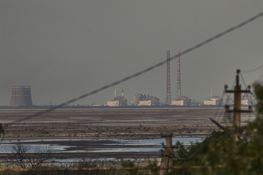 FILE - The Zaporizhzhia nuclear power plant, Europe's largest, is seen in the background of the shallow Kakhovka Reservoir after the dam collapse, in Energodar, Russian-occupied Ukraine, Tuesday, June 27, 2023. Ukraine and Russia accused each other Wednesday, July 5, 2023, of planning to attack the power plant, which is occupied by Russian troops, but neither side provided evidence to support their claims.