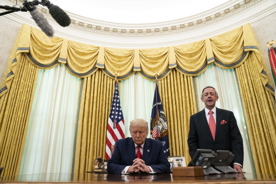 FILE - Pastor Robert Jeffress and President Donald Trump pray after Trump signed a full pardon for Alice Johnson in the Oval Office of the White House, Friday, Aug. 28, 2020, in Washington. Jeffress, pastor of an evangelical megachurch in Dallas, has been a staunch supporter of Trump since his first campaign for president. "Conservative Christians continue to overwhelmingly support Donald Trump because of his biblical policies, not his personal piety," Jeffress told The Associated Press via email.