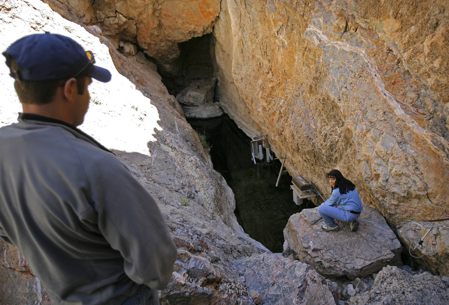 FILE - Biologist Mike Bower, left, with the National Park Service, and Fish and Wildlife Service field supervisor Cynthia Martinez, are seen in Devil's Hole, the endangered Devil's Hole Pupfish's only natural habitat, at Death Valley National Park in Nev., April 6, 2006. Federal land managers have formally withdrawn their authorization of a Canadian mining company's lithium exploration project bordering a national wildlife refuge in southern Nevada after conservationists sought a court order to block it. (AP Photo/Jae C.