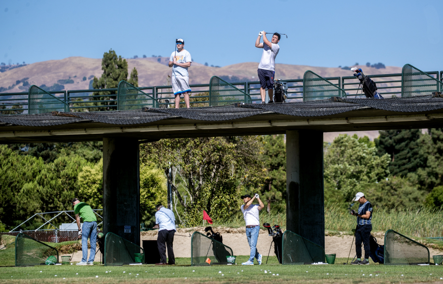Golfers practice at the double-decker driving range July 13 at the San Jose Municipal Golf Course in San Jose, Calif.