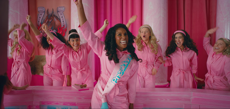 Issa Rae, surrounded by other Barbies, plays President of Barbieland in the new Warner Bros. film "Barbie." Some say the film about the historic doll franchise shines a light on the world today. (Courtesy of Warner Bros.