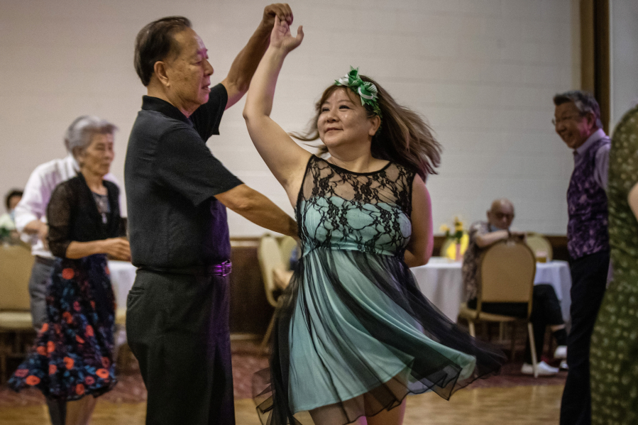 Hattie Peng, a survivor of the Monterey Park shooting, center, dances with a partner at the Elks Lodge on Wednesday, June 21, 2023, in San Gabriel, California.