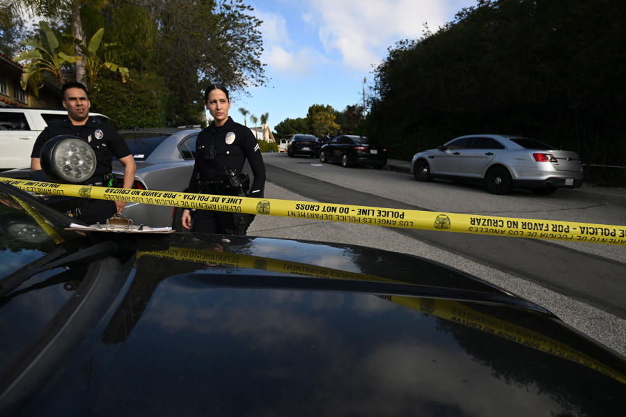 Police officers secure the crime scene after an early morning shooting that left three people dead and four wounded in the Beverly Crest neighborhood of Los Angeles on Jan. 28, 2023.