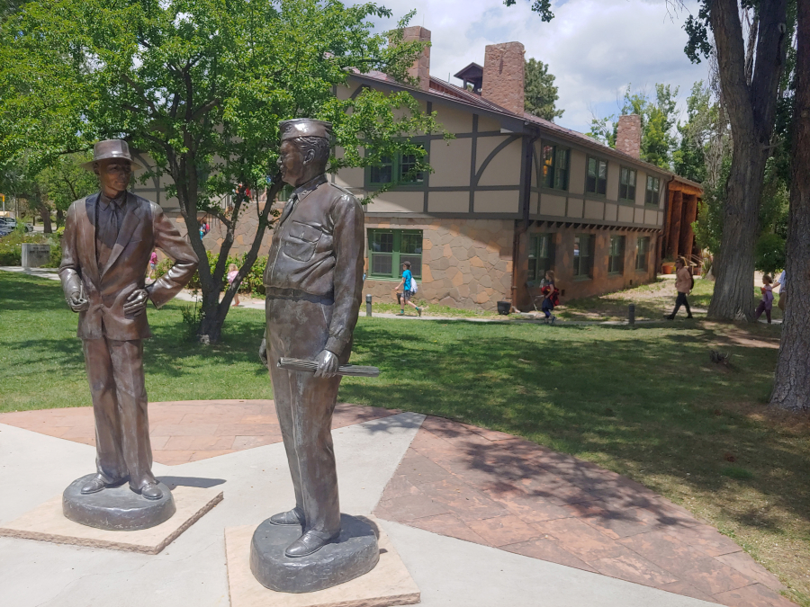 Statues of J. Robert Oppenheimer, left, and Gen. Leslie Groves stand outside the historic Fuller Lodge in Los Alamos, New Mexico.