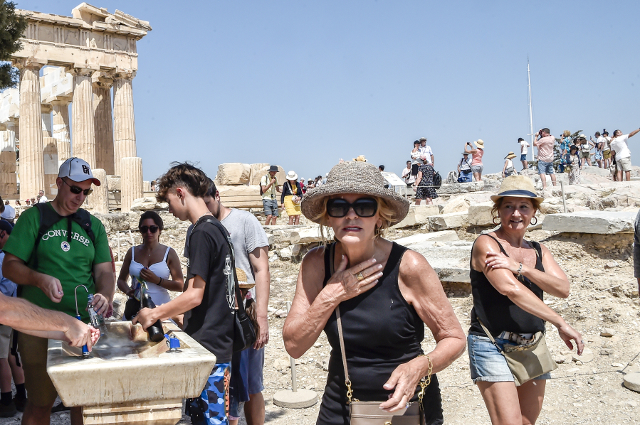 Tourists refresh with water in front of the 5th century B.C. Parthenon temple at the Acropolis hill during a heat wave on July 20 in Athens, Greece.