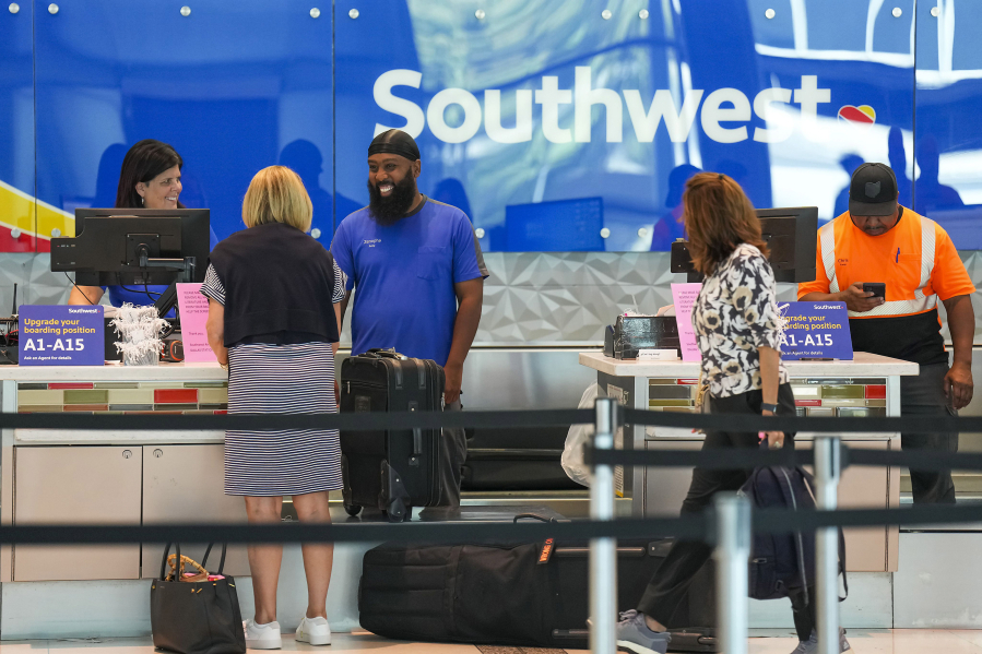 Southwest Airlines ticketing ramp agents work at a check in desk July 26 at Dallas Love Field Airport. (Smiley N.