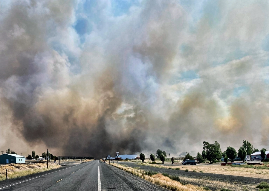 RETRANSMISSION TO CORRECT STATE - This photo provided by the Washington State Department of Transportation shows smoke from a wildfire burning south of Lind, Wash. on Thursday, Aug. 4, 2022. Sheriff's officials are telling residents in the town of Lind in eastern Washington to evacuate because of a growing wildfire south of town that was burning homes.