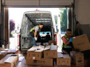 Batsukh Sevjid, center, and David Tamura load products onto a truck for deliveries to local restaurants July 18 at Young Ocean in Kent.
