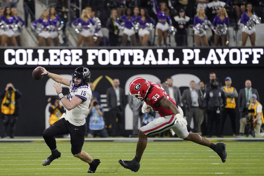 TCU quarterback Max Duggan (15) runs out of the pocket, chased by Georgia linebacker Robert Beal Jr. (33) during the second half of the national championship game Jan. 9, 2023, in Inglewood, Calif. The conference commissioners who manage the College Football Playoff met Wednesday, Aug. 30, 2023, for the first time since a wave of realignment tore apart the Pac-12, raising the possibility that the number of automatic bids in the 12-team postseason format to be implemented next year could be tweaked. (AP Photo/Mark J.
