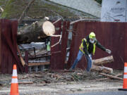 A Clark County Public Works employee help with clean-up after a tree crashed into a fence during a windstorm in January.